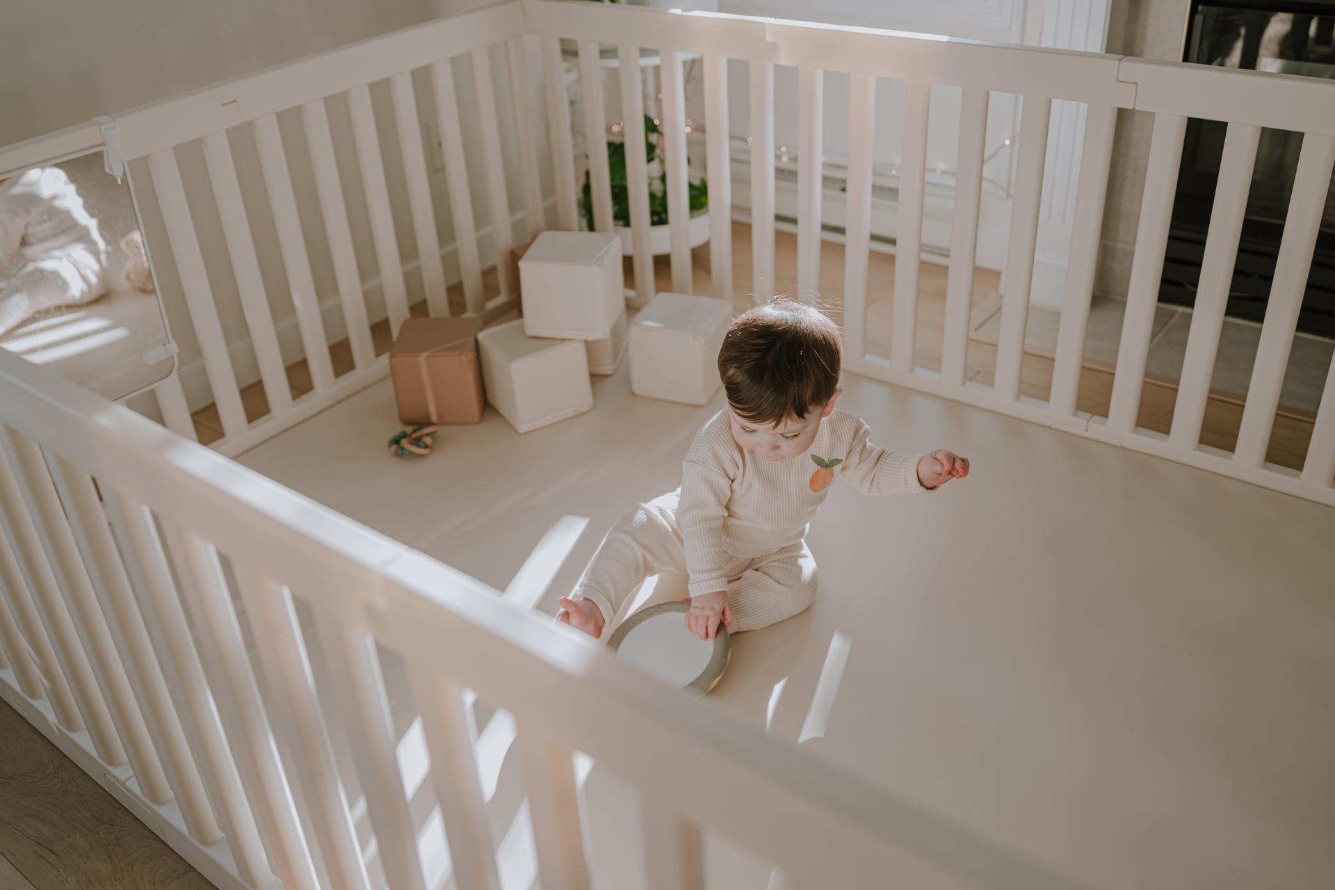 Baby playing on a Wunderkids non-toxic foldable play mat, creating a safe movement-based play space in a modern home.